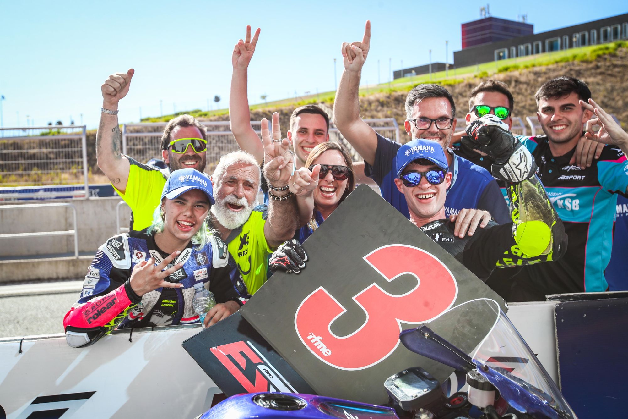 Héctor con la familia y el XE Racing Team celebrando el tercer puesto con la pizarra del 3